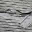 A badly damaged roof with missing shingles in need of repair