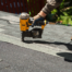 employee using nail gun to install new shingles