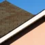 Roof Scams and How to Avoid Them - WorleyByrd Roofing: close-up of a home roofline and shingles under a clear Texas sky.