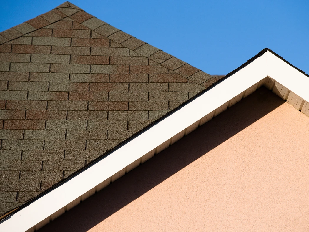 Roof Scams and How to Avoid Them - WorleyByrd Roofing: close-up of a home roofline and shingles under a clear Texas sky.